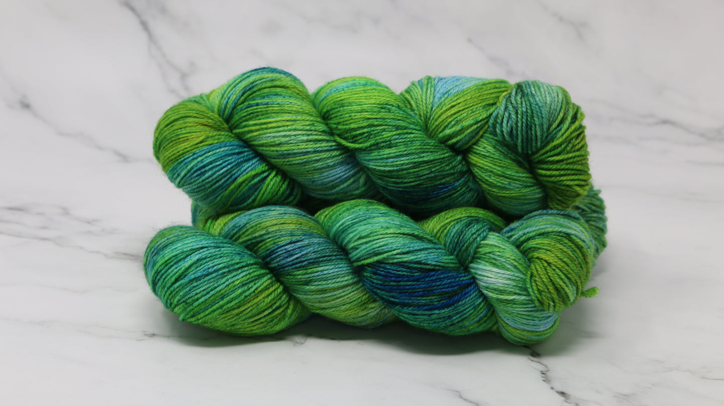 three skeins piled in tones of green and blue