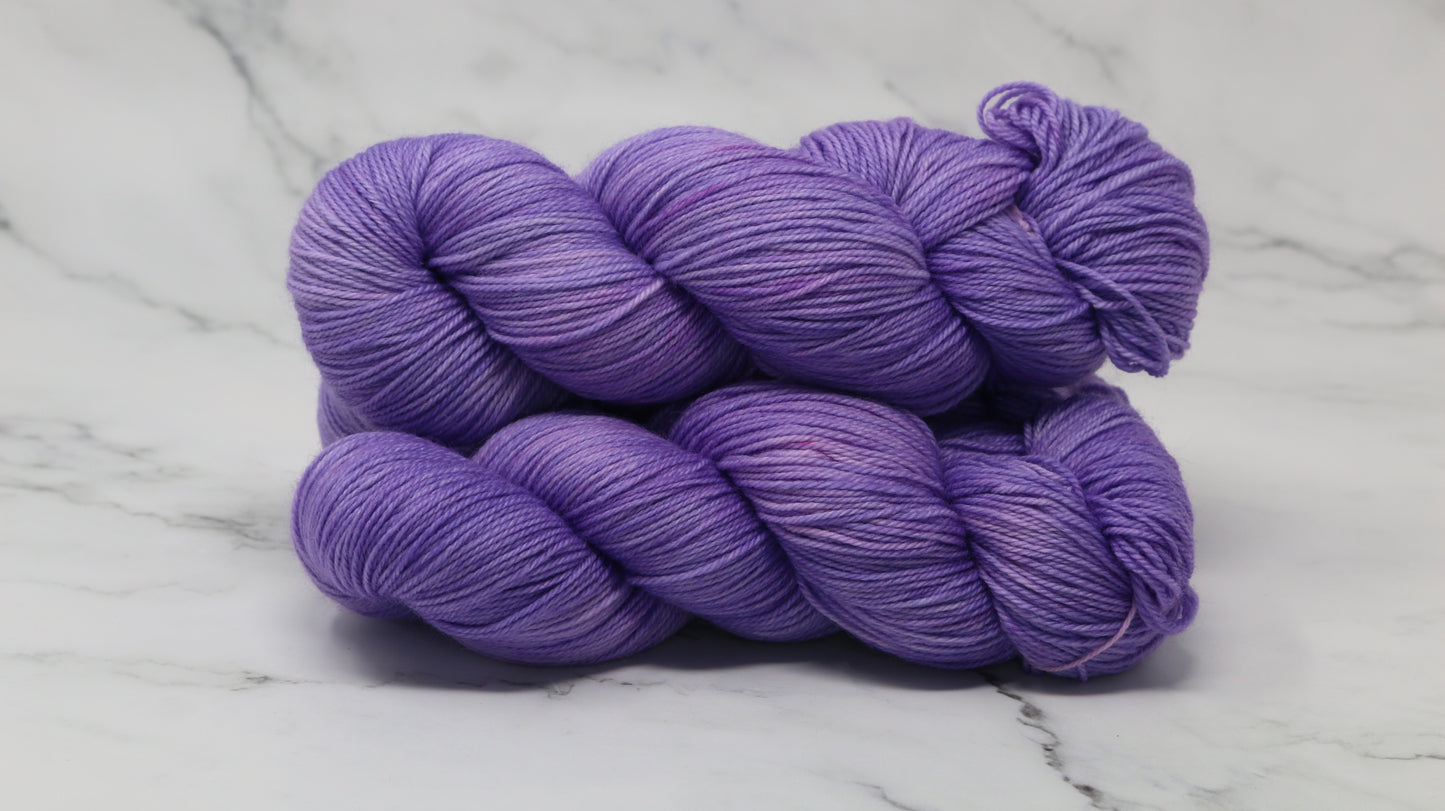 Stack of 3 purple skeins of yarn