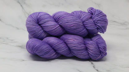 Stack of 3 purple skeins of yarn