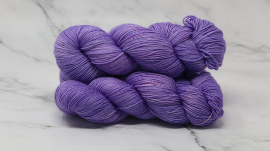 Stack of 3 purple skeins of yarn