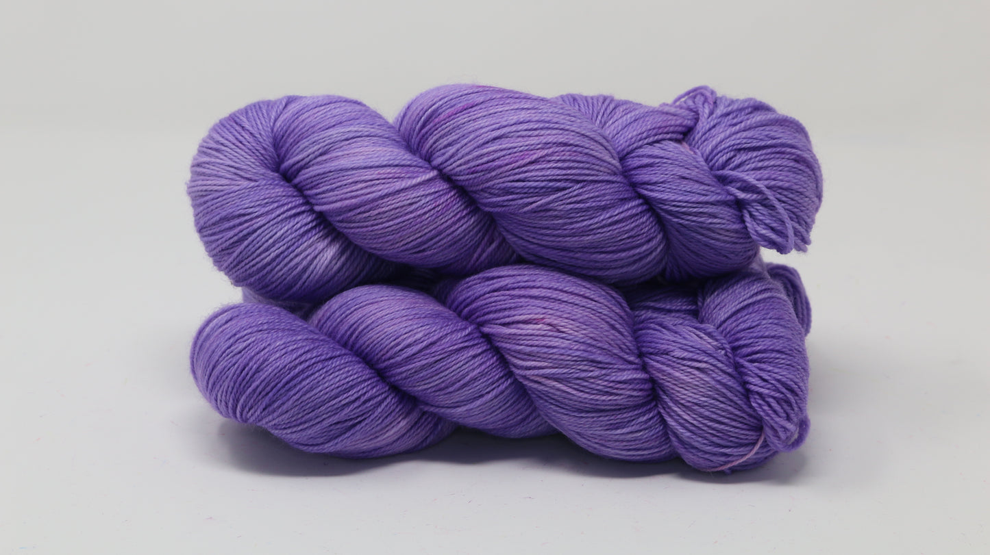 Stack of 3 purple skeins of yarn