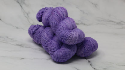 Stack of 3 purple skeins of yarn