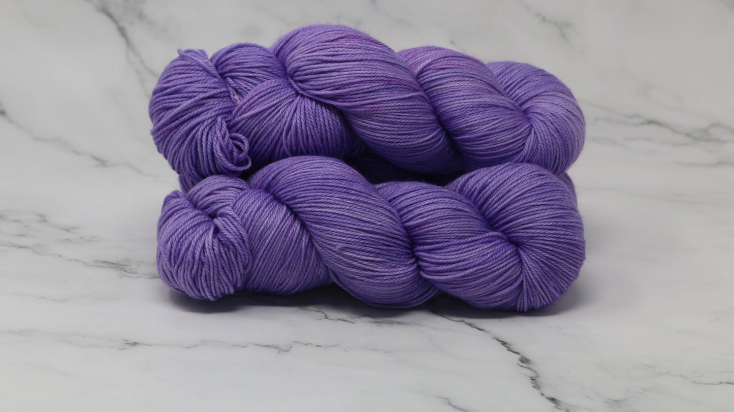 Stack of 3 purple skeins of yarn