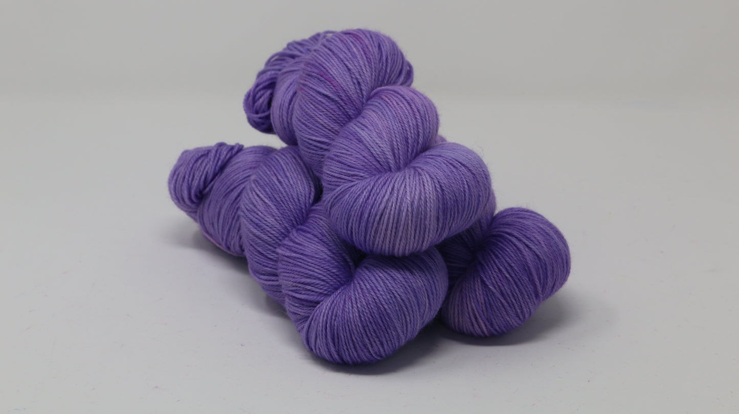 Stack of 3 purple skeins of yarn