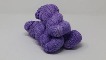 Stack of 3 purple skeins of yarn
