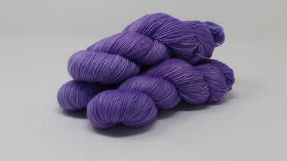 Stack of 3 purple skeins of yarn