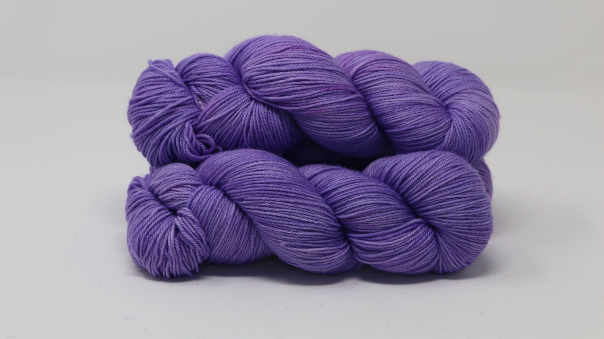 Stack of 3 purple skeins of yarn