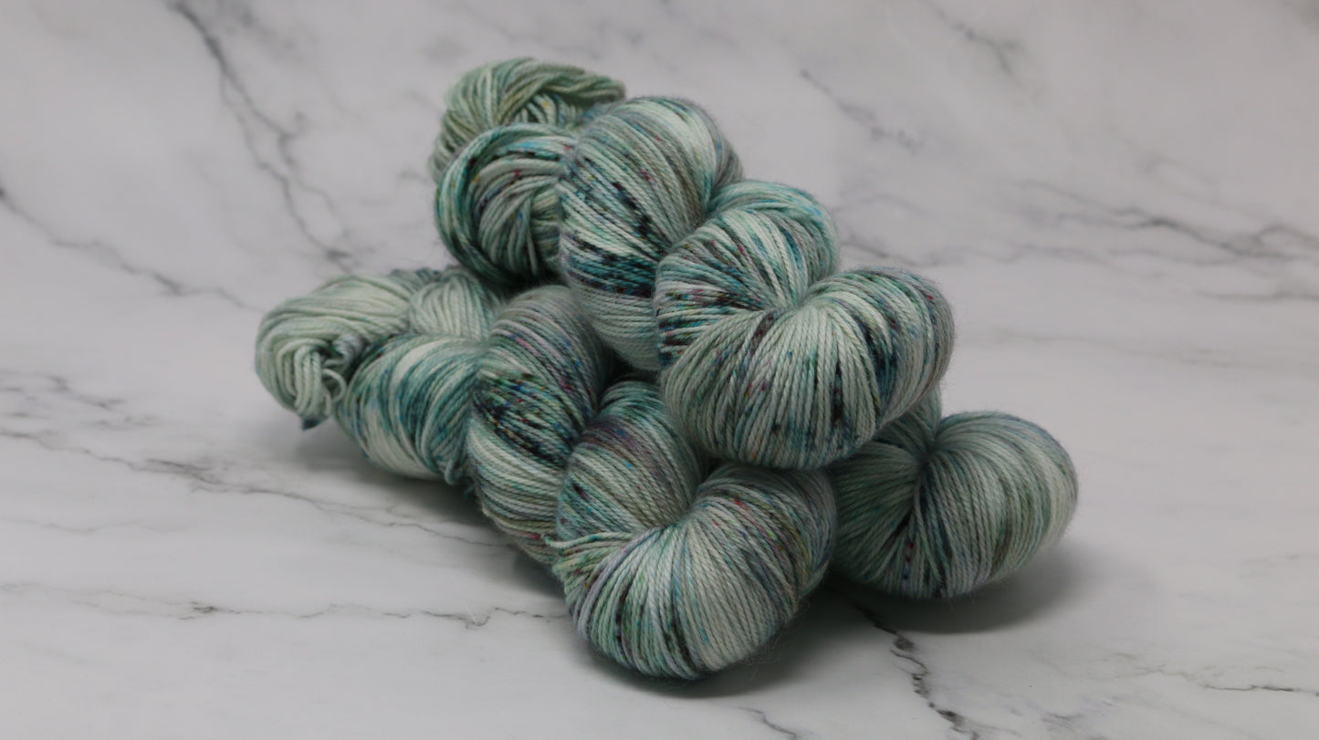 3 skeins of speckled yarn in green, blue, pink, brown
