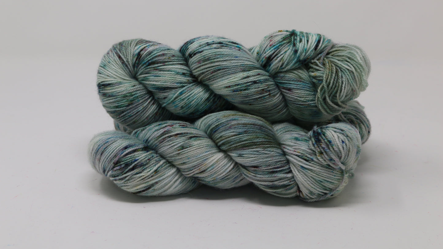 3 skeins of speckled yarn in green, blue, pink, brown