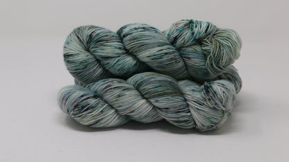 3 skeins of speckled yarn in green, blue, pink, brown