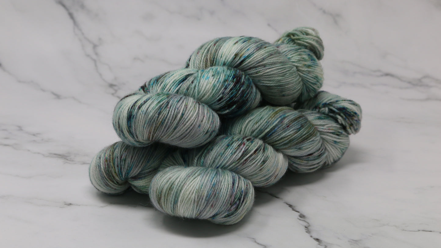3 skeins of speckled yarn in green, blue, pink, brown