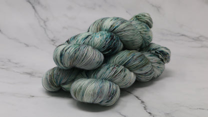 3 skeins of speckled yarn in green, blue, pink, brown