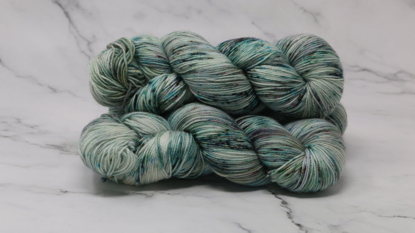 3 skeins of speckled yarn in green, blue, pink, brown