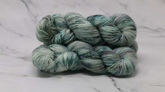 3 skeins of speckled yarn in green, blue, pink, brown