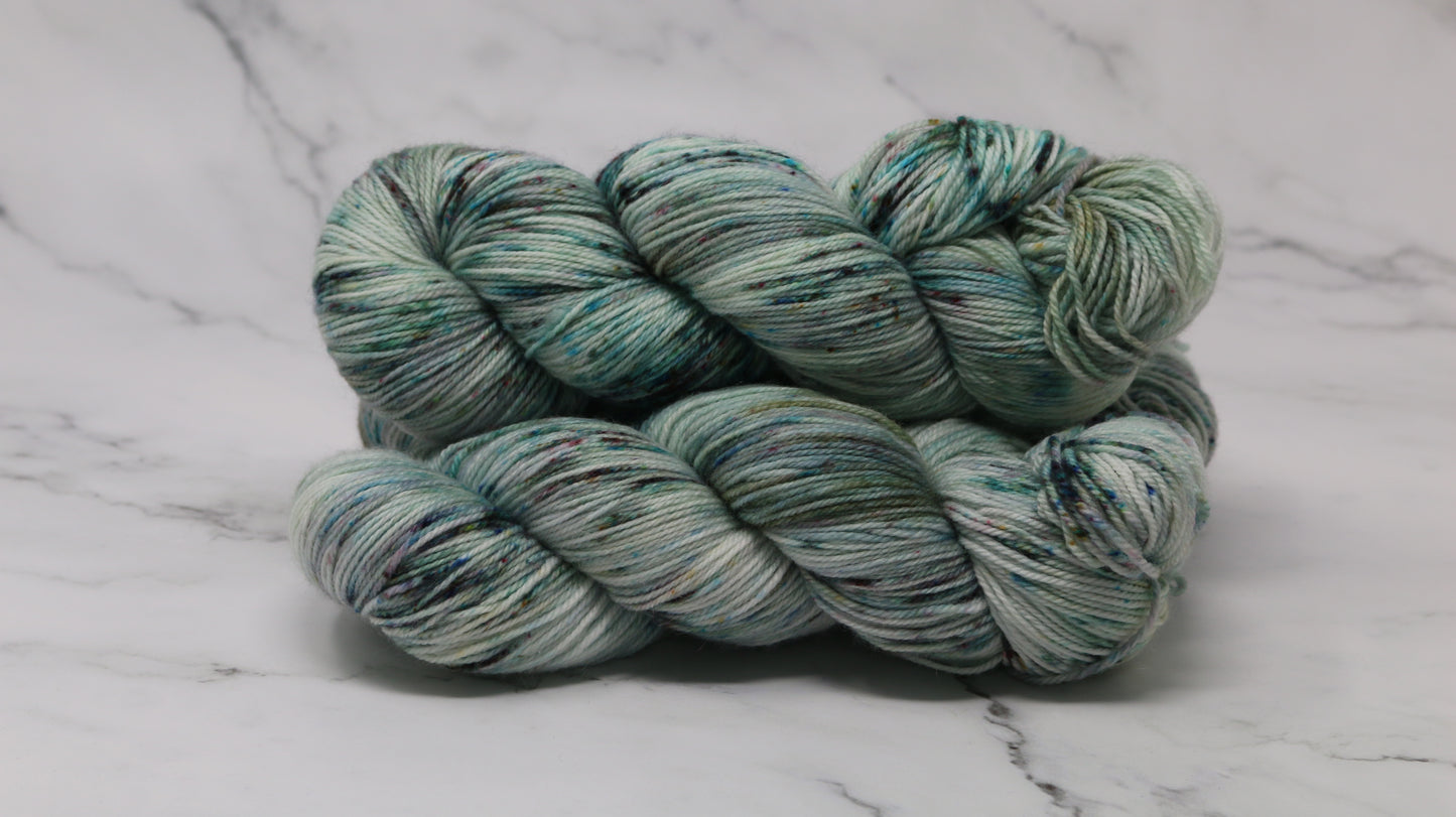 3 skeins of speckled yarn in green, blue, pink, brown