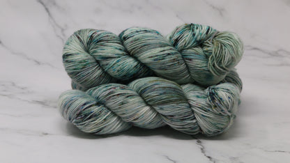 3 skeins of speckled yarn in green, blue, pink, brown