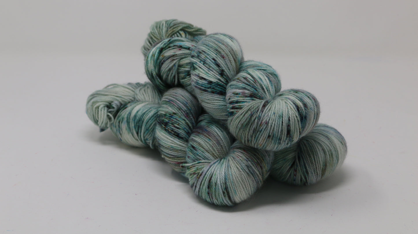 3 skeins of speckled yarn in green, blue, pink, brown
