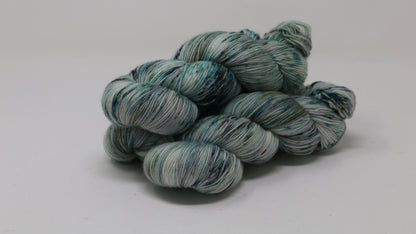 3 skeins of speckled yarn in green, blue, pink, brown