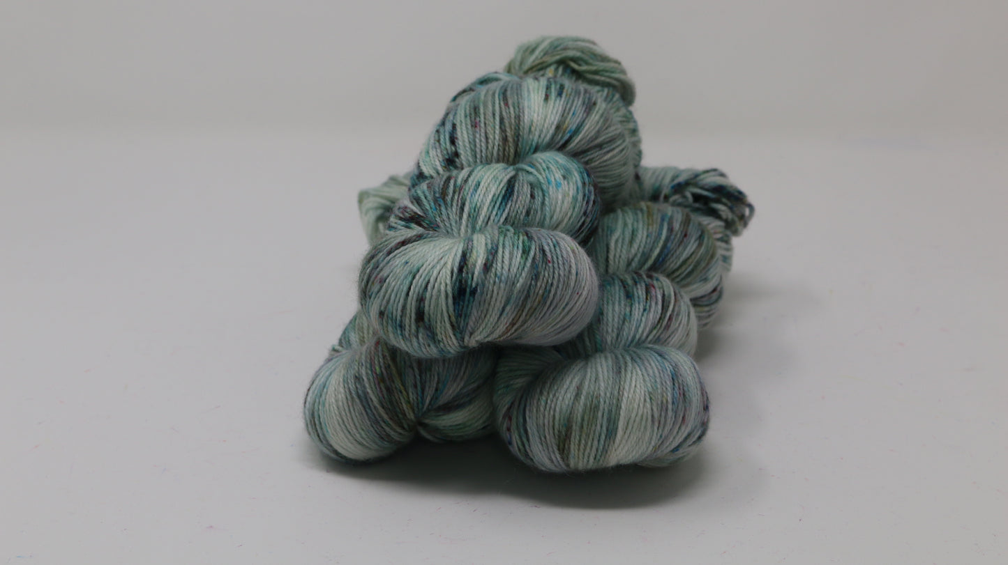 3 skeins of speckled yarn in green, blue, pink, brown