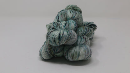 3 skeins of speckled yarn in green, blue, pink, brown