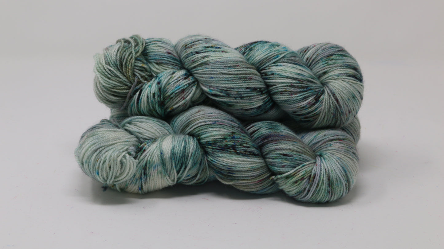 3 skeins of speckled yarn in green, blue, pink, brown