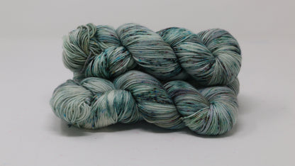 3 skeins of speckled yarn in green, blue, pink, brown