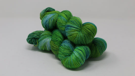 three skeins piled in tones of green and blue