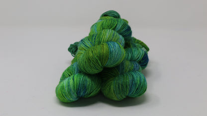 three skeins piled in tones of green and blue