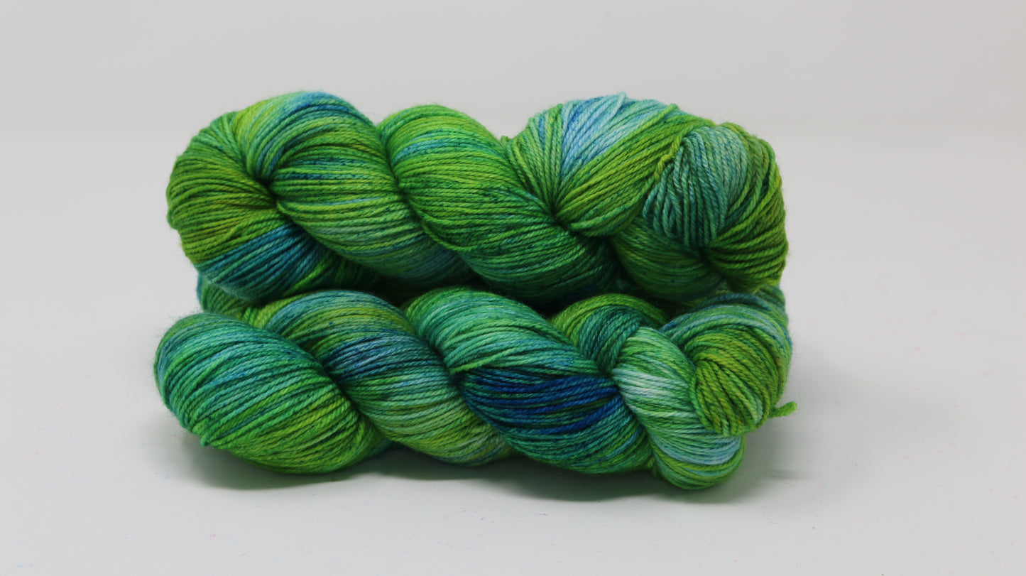 three skeins piled in tones of green and blue