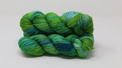 three skeins piled in tones of green and blue