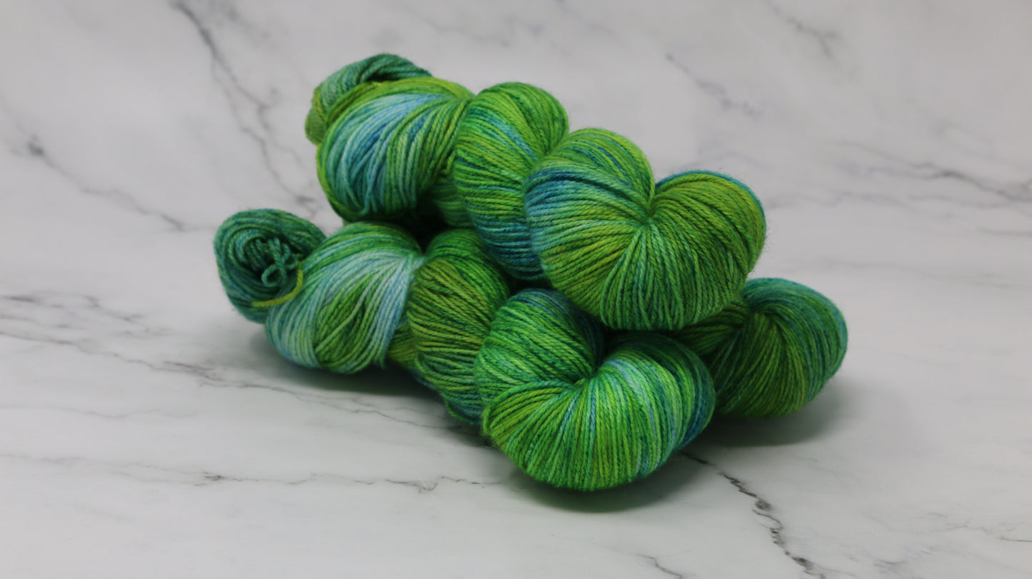 three skeins piled in tones of green and blue