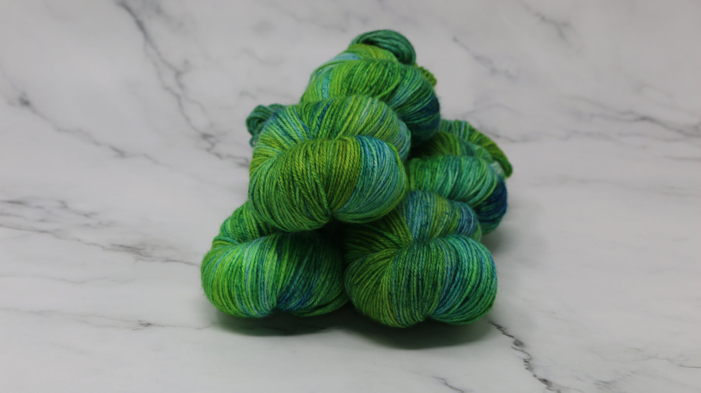 three skeins piled in tones of green and blue