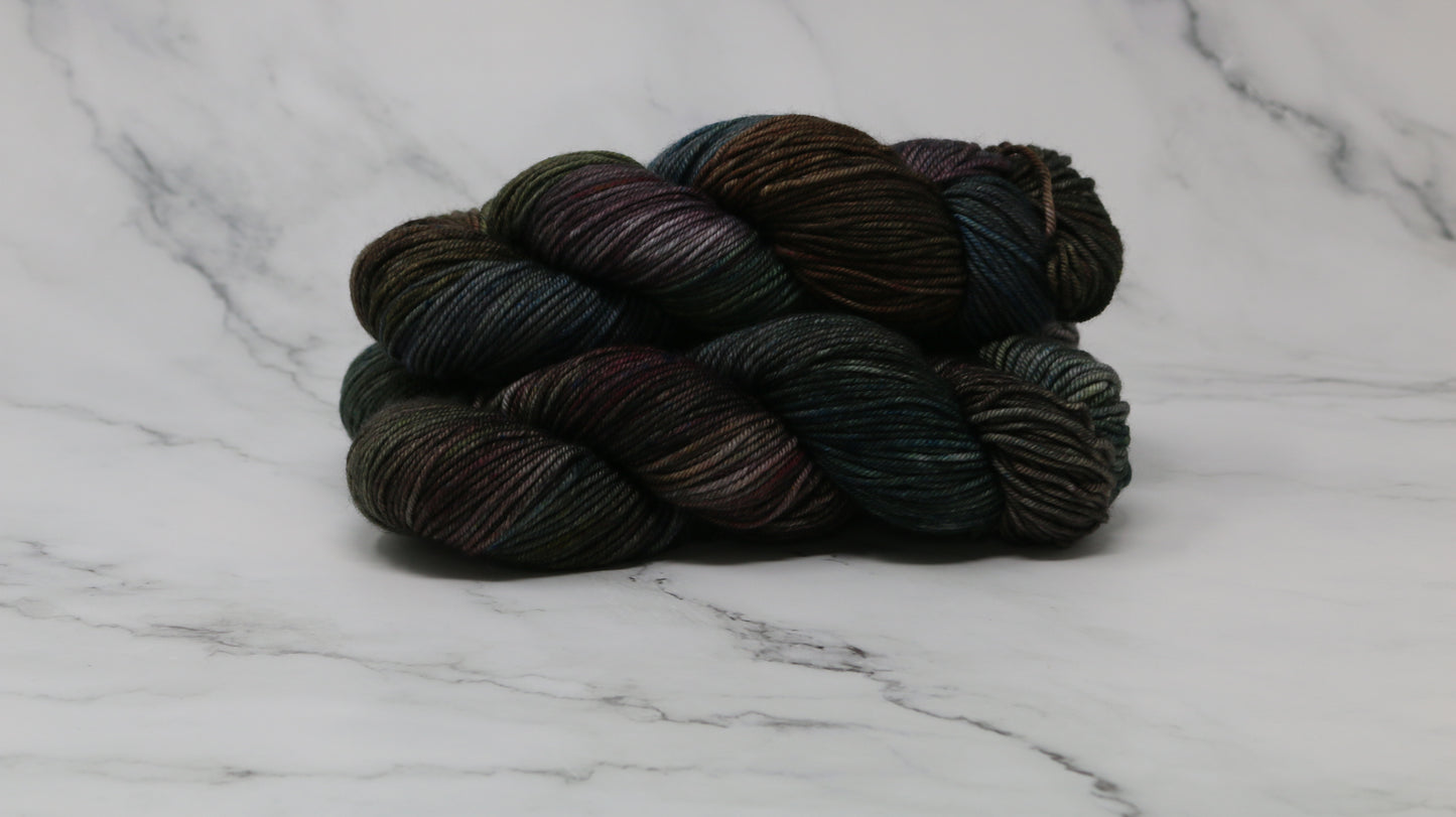 Three skeins of multicolored yarn on a white marble surface