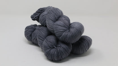 Three skeins of yarn in a tonal dark grey colour
