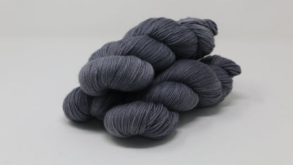 Three skeins of yarn in a tonal dark grey colour