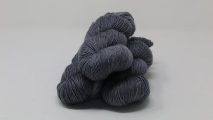 Three skeins of yarn in a tonal dark grey colour