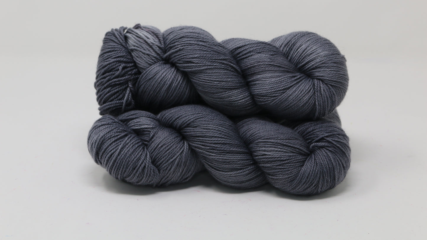 Three skeins of yarn in a tonal dark grey colour