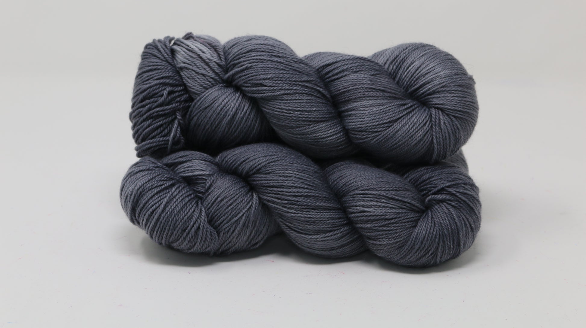 Three skeins of yarn in a tonal dark grey colour