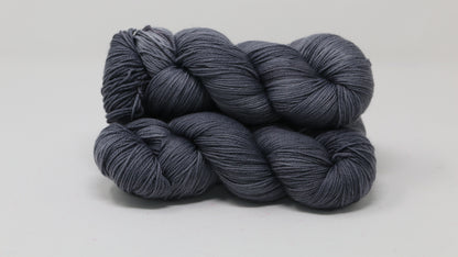 Three skeins of yarn in a tonal dark grey colour