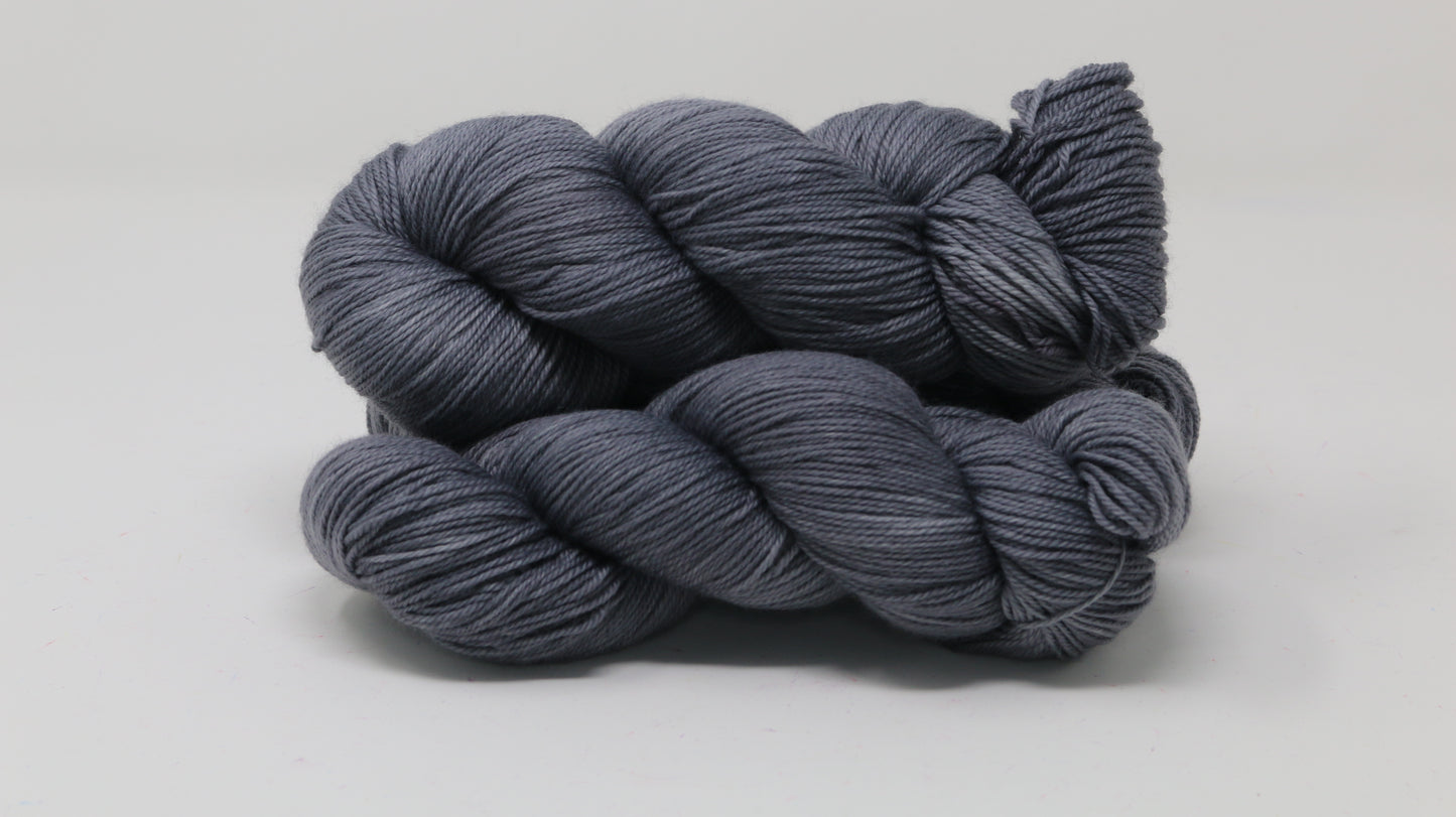 Three skeins of yarn in a tonal dark grey colour