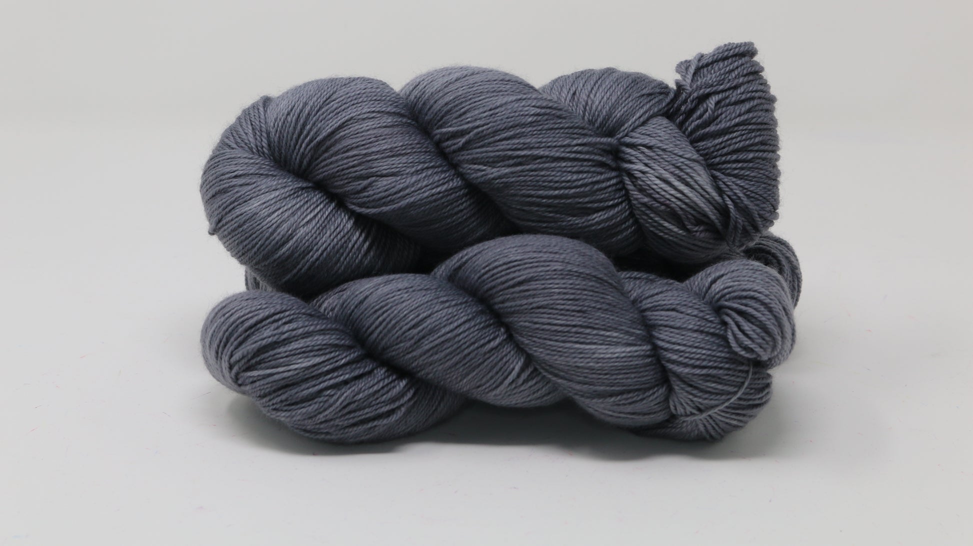 Three skeins of yarn in a tonal dark grey colour