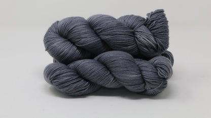 Three skeins of yarn in a tonal dark grey colour