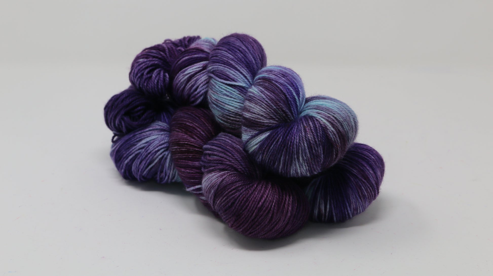 Three skeins of variegated purple and blue yarn