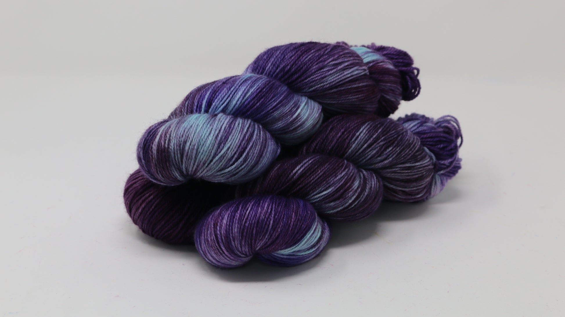 Three skeins of variegated purple and blue yarn