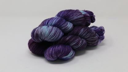 Three skeins of variegated purple and blue yarn