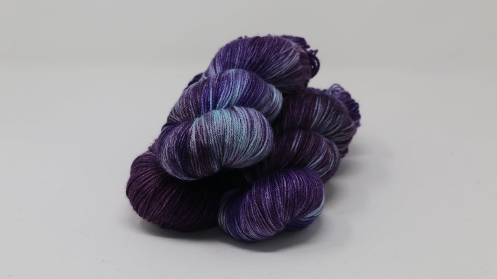Three skeins of variegated purple and blue yarn