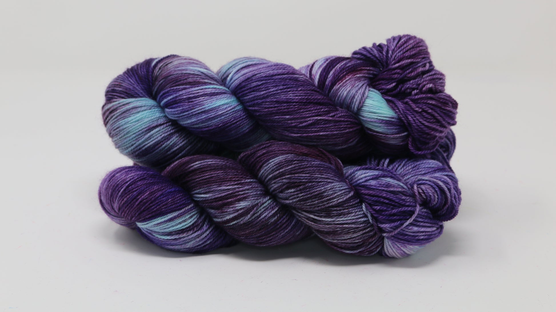 Three skeins of variegated purple and blue yarn