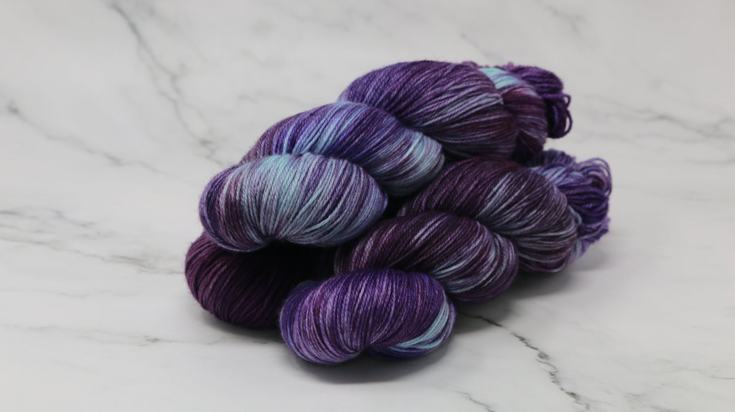 Three skeins of variegated purple and blue yarn