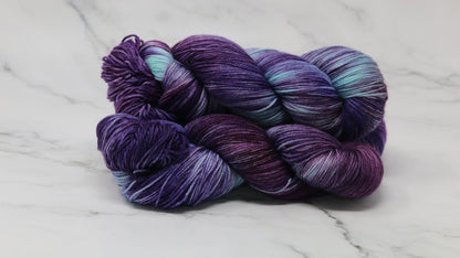Three skeins of variegated purple and blue yarn