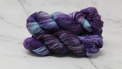 Three skeins of variegated purple and blue yarn